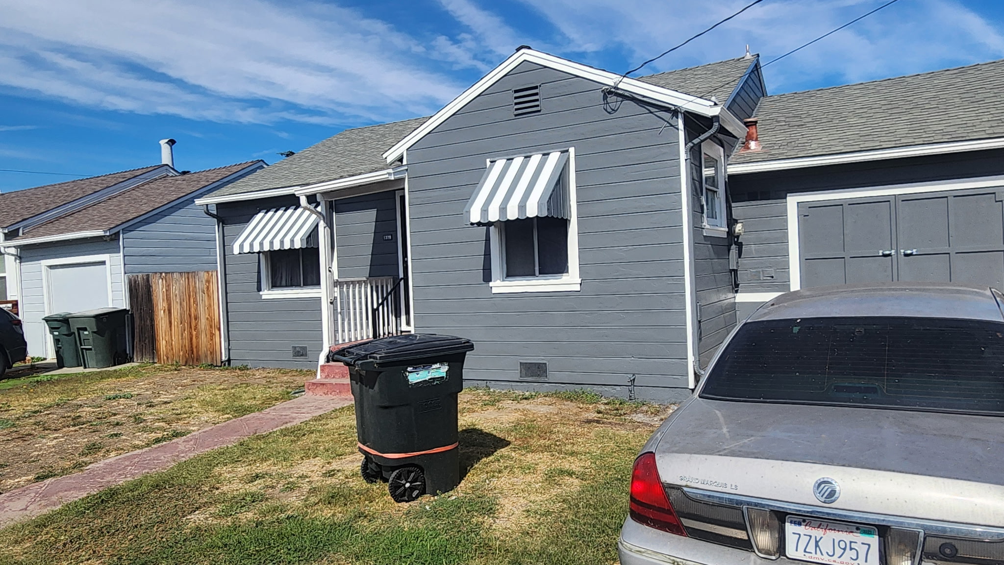 Freshly painted residential exterior showing gray siding and white trim
